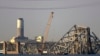 Sebuah derek terlihat di dekat reruntuhan Jembatan Francis Scott Key pada Jumat, 29 Maret 2024 di Baltimore. Sebuah kapal kargo menabrak jembatan utama di Baltimore pada Selasa pagi, menyebabkan jembatan itu roboh dalam hitungan detik. (Foto: AP)