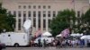 Media and protesters gather at the E. Barrett Prettyman U.S. Federal Courthouse, in Washington, Aug. 3, 2023, ahead of former President Trump's arraignment on charges of having tried to overturn the results of the 2020 election in his favor. 