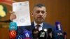FILE - Haider Hanoun, the head of Iraq's Commission for Integrity, the government's anti-corruption agency, displays a document during a press conference in Baghdad, June 22, 2023, concerning cases uncovered by the commission.