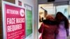 FILE - A sign announcing a face mask requirement is displayed at a hospital in Buffalo Grove, Ill., Jan. 13, 2023. COVID-19 hospital admissions have been inching upward in the U.S. since early July. It's a small-scale echo of the three previous summers.