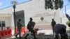 FILE - A man carries his belongings after officers of the Haitian National Police fired tear gas to clear a camp of people escaping the threat of armed gangs, in front of the U.S. Embassy, in Port-au-Prince, Haiti, July 25, 2023. 