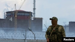 FILE - A serviceman with a Russian flag on his uniform stands guard near the Zaporizhzhia Nuclear Power Plant amid Russia's war on Ukraine, outside the Russian-controlled city of Enerhodar in the Zaporizhzhia region, Ukraine, Aug. 4, 2022. 