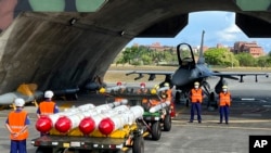 台湾军队士兵站在F16V战机前，准备进行装载美制AGM-84鱼叉反舰导弹及AIM-120和AIM-9空空导弹的训练。（美联社2022年9月16日）