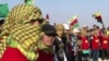 Members of a Kurdish militia and the Free Syrian Army rebels forces stand guard at a check point in Ras al-Ain on the border with Turkey, Feb. 27, 2013. Kurds now control the strategic town.