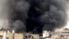 A citizen journalism image provided by Aleppo Media Center, which has been authenticated based on its contents and other AP reporting, shows black smoke rising from buildings due to government forces shelling, in Aleppo, Syria, March 19, 2013.