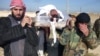 Free Syrian Army fighters carry the body of their comrade who died during clashes with forces loyal to Syria's President Bashar al-Assad, in Qusair town near Homs, March 25, 2013. 