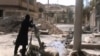 Free Syrian Army fighters drop shell into a firing tube, in Damascus countryside, Syria, Mar 24,2013 (Ugarit News via AP video)