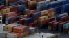 FILE - Workers stand on the deck of a container vessel as it is unloaded at a container terminal in Liverpool, northern England, Dec. 9, 2016.