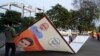 Petugas membereskan spanduk yang menampilkan gambar Perdana Menteri India Narendra Modi di Lucknow, Uttar Pradesh, pada 16 Maret 2024. (Foto: AP/Rajesh Kumar Singh)