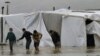 Syrian refugee boys make their way in flooded water at a temporary refugee camp in eastern Lebanese town of Al-Faour, near the Syrian border, Jan. 8, 2013.