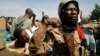 Malian soldiers guard suspected Islamist extremists after throwing them in the back of the army truck in Gao, Mali, January 29, 2013. 