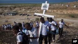 Relatives of those who died in the 2010 earthquake walk to place a cross on a hilltop to remember those who died in the devastating earthquake atTitanyen, a mass burial site north of Port-au-Prince, Haiti, Jan. 12, 2013.