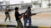 Militia fighters are seen shooting at a building in center of Bani Walid, Libya, October 24, 2012. 