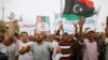 Protesters wave a Libyan flag as they demonstrate in Martyrs' Square demanding Gadhafi-era officials to be banned from taking up political posts, in Tripoli, Libya, May 5, 2013.