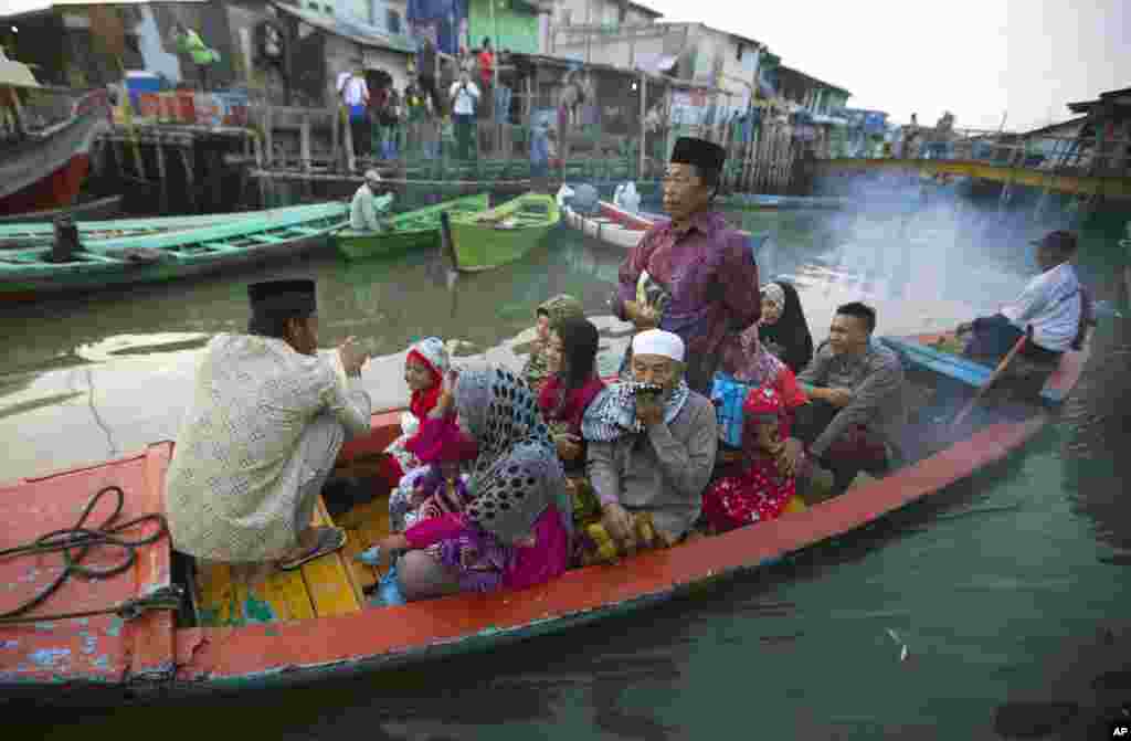 Indonesian Muslims leave their village by long boat to offer Eid al-Fitr prayers, in North Jakarta, Indonesia, July 28, 2014.