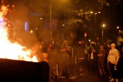 Protesters stand by a burning barricade in Barcelona, Spain, Oct. 19, 2019. Radical separatists have clashed with police each night in Barcelona and other Catalan cities following huge peaceful protests.