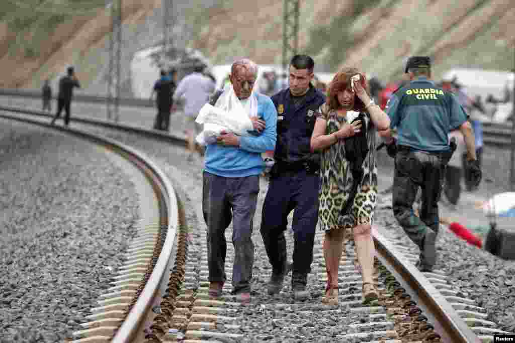 Victims are helped by rescue workers after a train crashed near Santiago de Compostela, Spain, July 24, 2013. 