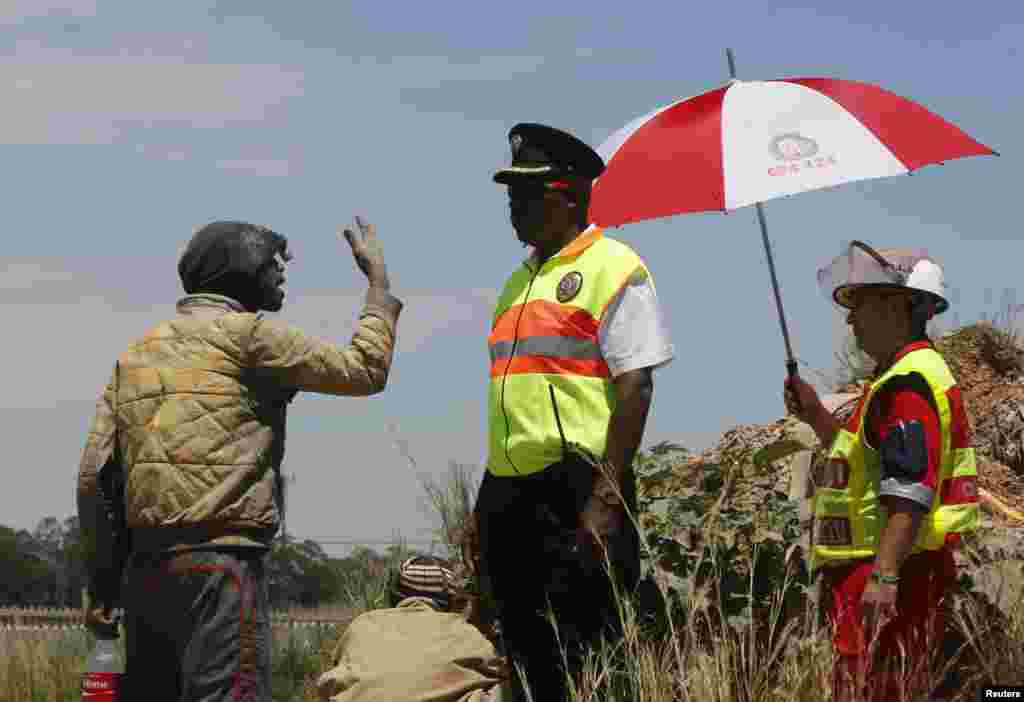 A suspected illegal miner talks to emergency personnel after emerging from an abandoned gold shaft in Benoni, east of Johannesburg, South Africa, Feb. 17, 2014. 