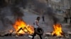 Palestinians burn tires during Israeli military raid in the West Bank city of Nablus, Oct. 6, 2015. 