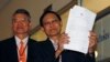 Thailand's Attorney Director General, Department of Special Litigation Chutichai Sakhakorn (R) holds filed charge papers as Director General, Department of Investigation, Surasak Threerattrakul looks on at the Supreme Court in Bangkok, February 19, 2015.