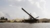 FILE PHOTO - This Aug. 2, 2011 photo shows a sand depot just outside the provincial capital of Koh Kong in southwestern Cambodia. It is owned by Ly Yong Phat, one of the country's biggest tycoons who is being criticized for the environmental damage his sand mining operations inflict on the Cambodian coast. Most of the sand is destined for Singapore. (AP Photo/Heng Sinith)