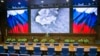 Lieutenant General Sergei Rudskoi of the Russian Military General Staff (background center), speaks to the media in Moscow, March 18, 2016. The screen shows an aerial image of an airstrike during the attack of Russian warplanes in Syria.