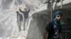 People search for survivors in the rubble of a damaged area that activists said was a result of an airstrike by the Syrian regime, in the Al-Sukkari neighborhood in Aleppo, Syria, April 7, 2013.