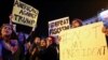 Anti-Trump protesters hold banners during a demonstration at Puerta del Sol Square in Madrid, Spain, Dec. 2, 2016. 