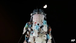 Participants climb up the bun tower during the bun snatching competition on the outlying Cheung Chau island in Hong Kong, Bun Festival. 