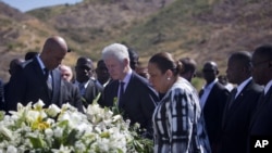 Haiti's President Michel Martelly, left, and UN special envoy to Haiti and former President Bill Clinton attend memorial in Haiti, Jan. 12, 2013