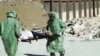 FILE - People in protective suits and gas masks conduct a drill on how to treat casualties of a chemical weapons attack in Aleppo, Syria. Islamic State fighters reportedly fired rockets loaded with mustard gas into a town north of Baghdad late Tuesday and early Wednesday. 