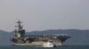 Một tàu chở khách Việt Nam chạy gần Hàng không mẫu hạm Carl Vinson đang neo ở cảng Tien Sa, Đà Nẵng ngày 5/3/2018. (AP Photo/ Hau Dinh)