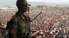 A soldier from the M23 rebel group looks on as thousands of Congolese people listen during an M23 rally, in Goma, eastern Congo, Nov. 21, 2012