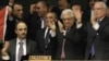 Members of the Palestinian delegation react as they surround Palestinian President Mahmoud Abbas, center, who applauds during a meeting of the U.N. General Assembly after a vote on a resolution on the issue of upgrading the Palestinian Authority status in New York, Nov. 29, 2012. 