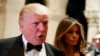 Melania Trump, right, looks on as her husband President-elect Donald Trump talks to reporters during a New Year's Eve party at Mar-a-Lago, Dec. 31, 2016, in Palm Beach, Florida. On Tuesday, Trump criticized the largest U.S. automaker for sending its Mexican-made Chevrolet Cruze compact models back to U.S. car dealers tax free.
