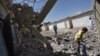 Syrian boys pick through the rubble of their school in Tal Rifat, Syria after it was bombed by Syrian planes in recent months.