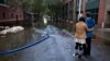 Steve Brett and his wife, Toi Brett, of Hoboken, N.J., look down First Street at high water near their home in Hoboken, N.J., Oct. 31, 2012, in the wake of superstorm Sandy. 
