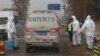 FILE - Workers disinfect passing vehicles in an area after the latest incident of African swine flu outbreak on the outskirts of Beijing, China, Nov. 23, 2018.