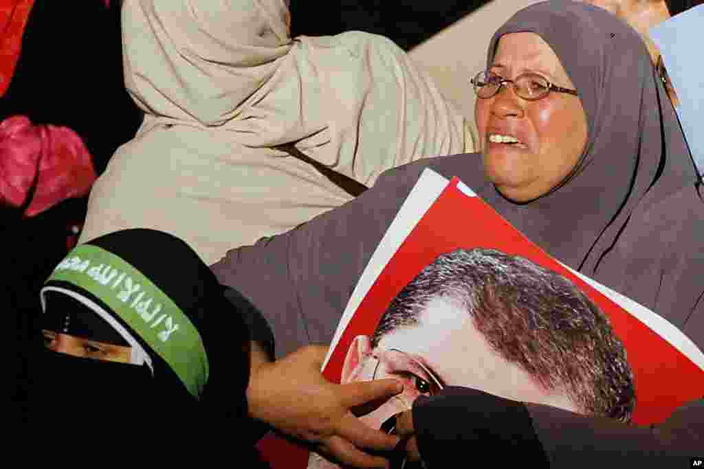Một người ủng hộ Tổng thống bị lật đổ Mohamed Morsi khóc khi bà giữ chặt tấm hình của ông, Cairo 3-7-2013.