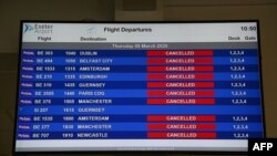 Sebuah papan keberangkatan penerbangan elektronik menampilkan status 'dibatalkan' untuk semua penerbangan Flybe di Bandara Exeter di Exeter, Inggris, 5 Maret 2020. (Foto: AFP)