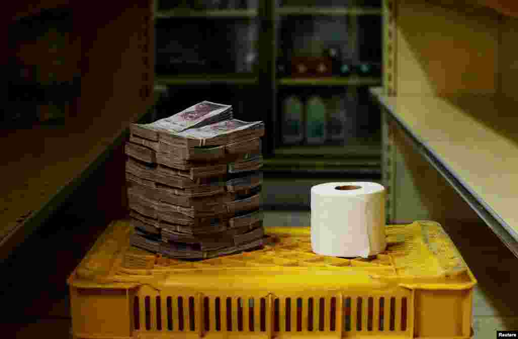 A roll of toilet paper next to 2,600,000 bolivars needed to buy it, the equivalent of $0.40.