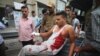 An injured Indian civilian of cross border firing gets down from an ambulance at the Government Medical College hospital in Jammu, India, Friday, Aug. 28, 2015.