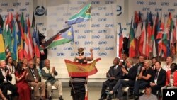 Youth delegates hold their national flags during the opening ceremony for the One Young World summit at Soccer City in Johannesburg, South Africa, Oct. 2, 2013. 