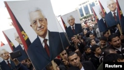 Palestinians hold placards depicting President Mahmoud Abbas during a rally in support of his efforts to secure a diplomatic upgrade at the United Nations, in the West Bank city of Ramallah, November 25, 2012.