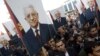 Palestinians hold placards depicting President Mahmoud Abbas during a rally in support of his efforts to secure a diplomatic upgrade at the United Nations, in the West Bank city of Ramallah, November 25, 2012.