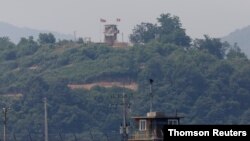 দক্ষিণ কোরিয়ার পাজু থেকে তোলা ফাইল ছবিতে দুই কোরিয়াকে বিচ্ছিন্নকারী ডিএমজি পাহারায় গার্ড পোস্টে দাঁড়িয়ে উত্তর কোরিয়ার সেনা, ১৭ই জুন ২০২০/রয়টার্স
