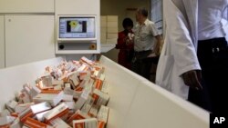 A newly mechanized pharmaceutical machine that helps pharmacists dispense medicine is loaded with ARV medication, at the U.S. sponsored Themba Lethu, HIV/AIDS Clinic, at the Helen Joseph hospital, in Johannesburg, South Africa, Nov. 15, 2012.