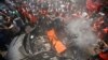 Palestinians gather around the remains of a car, which witnesses said was hit by an Israeli airstrike, in Gaza City, Aug. 24, 2014. 