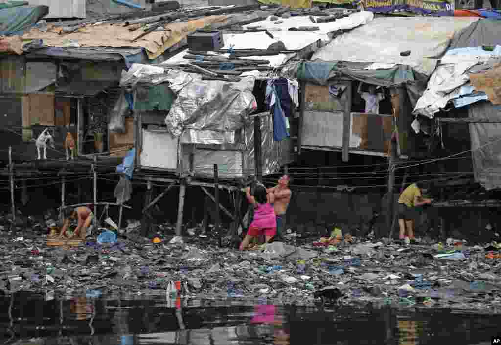 Residents strengthen their homes built on stilts as they brace for incoming Typhoon Rammasun, beside Manila&#39;s bay, Philippines.