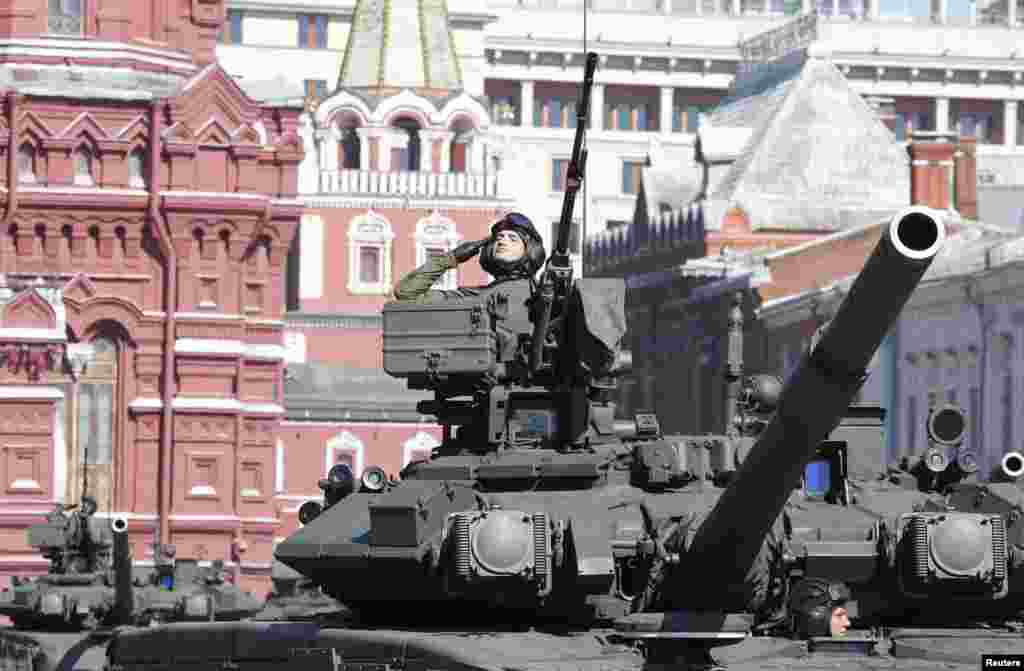 A Russian serviceman aboard a tank salutes during the Victory Day parade in Moscow's Red Square, May 9, 2014.